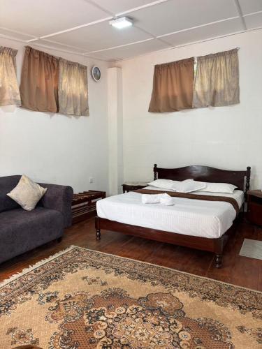 a bedroom with a bed and a couch at The Tamarind Villa in Kandy