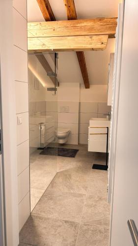 a bathroom with a toilet and a glass door at Haus Friedau in Ellmau