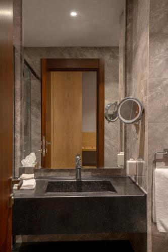 ein Badezimmer mit Waschbecken und Spiegel in der Unterkunft Radisson Hotel Madinah in Medina