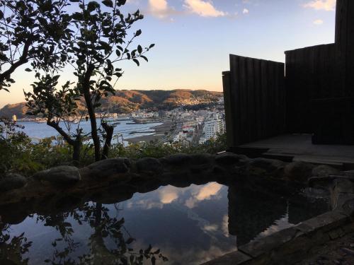 a reflection of a city in a body of water at Beach Commune Simploose (Adult Only) in Ito