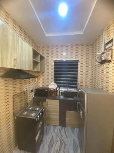 a small kitchen with a sink and a refrigerator at Asika Luxe Living in Ayobo