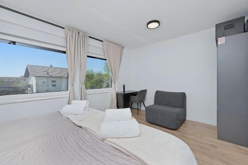 a bedroom with a bed and a chair and a window at House AGAPE near Zagreb with rooftop jacuzzi in Kerestinec