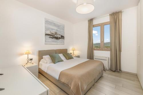 a white bedroom with a large bed and a window at B&B Il Connubio - Rooms & Apt between Florence and Chianti in Impruneta