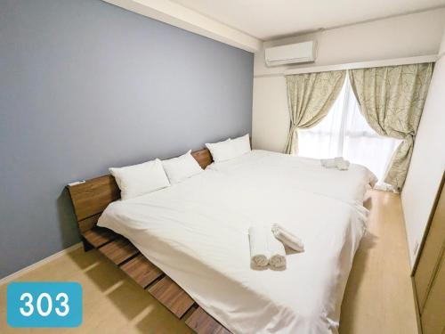 a small bedroom with a bed with shoes on it at Chateau Sunrise in Tokyo
