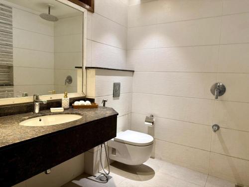 a bathroom with a toilet and a sink and a mirror at Luxury Stay Near Neelum River Valley,208 in Muzaffarabad