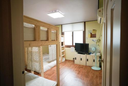 a room with two bunk beds and a television at Suncheon Namu Guesthouse in Suncheon