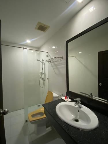 a bathroom with a sink and a shower and a mirror at SR Phuket in Patong Beach