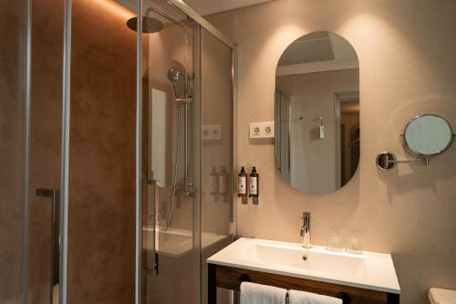 a bathroom with a shower and a sink and a mirror at Petit Palace Preciados in Madrid