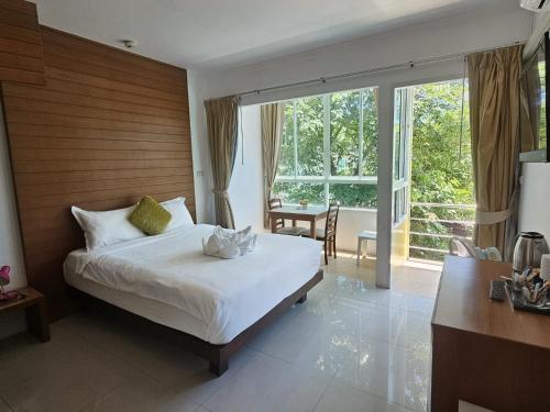 a bedroom with a bed and a large window at SR Phuket in Patong Beach