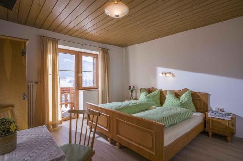 ブリクセン・イム・ターレにあるPension Straifhofのベッドルーム1室(緑の枕が付いたベッド1台付)