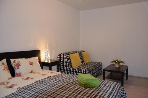 a bedroom with a bed and a chair and a chair at Apartments Ozo Park in Vilnius