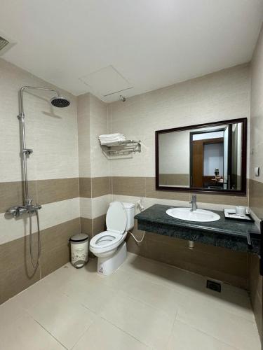 a bathroom with a toilet and a sink and a mirror at Sen Biển Hotel Luxury Sầm Sơn in Sầm Sơn