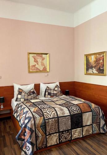 a bedroom with a bed and two pictures on the wall at Pension Madara in Vienna