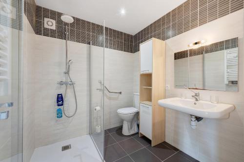 a bathroom with a shower and a sink and a toilet at Chambre d'hote chez Odile in Plougoulm