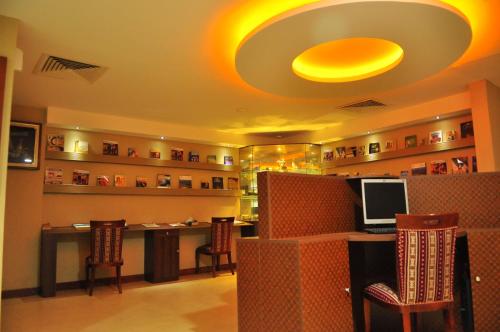 a lobby with a desk with a computer and chairs at Al Bahjah Hotel in Seeb