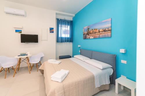 a bedroom with a bed and a table and a tv at Sale e Salsedine in Bari