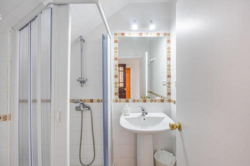 a white bathroom with a sink and a shower at Isabel Casa del Mar in Conil de la Frontera