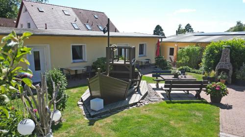 a garden with benches and tables and a house at Ferienanlage in Sellin auf Ruegen in Baabe