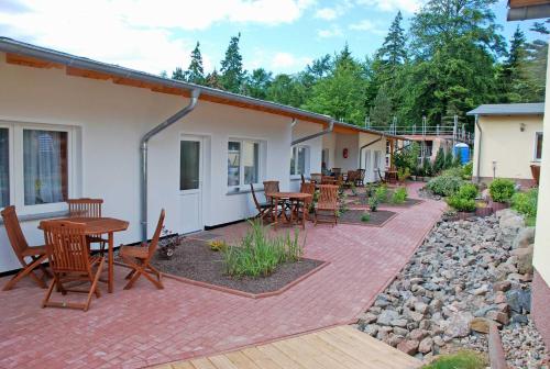 a patio with tables and chairs on a house at Ferienanlage in Sellin auf Ruegen in Baabe