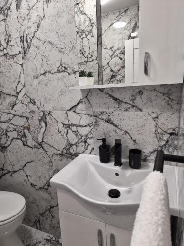 a white bathroom with a sink and a toilet at Apartments Villa Agape Vir in Vir