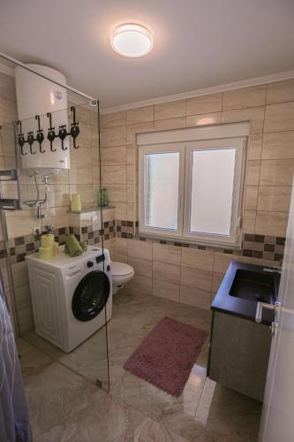 a bathroom with a washing machine and a sink at Apartment Baki in Jajce