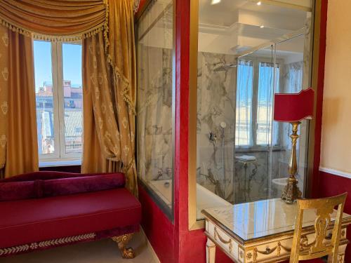 a living room with a red couch and a glass table at Romanico Palace Luxury Hotel & SPA in Rome