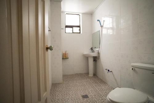 a bathroom with a toilet and a sink at Suncheon Namu Guesthouse in Suncheon