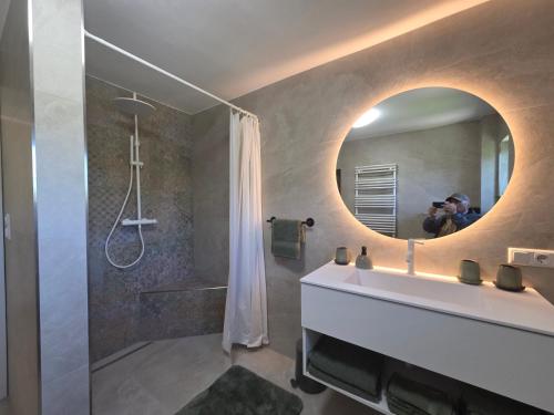 a person taking a picture of a bathroom with a mirror at Haus Königsreiter, der besondere Platz in Altmünster