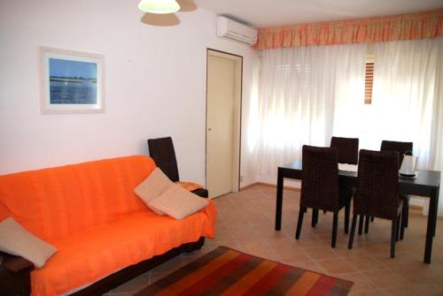 a living room with an orange couch and a table at Santis Appartament in Grado