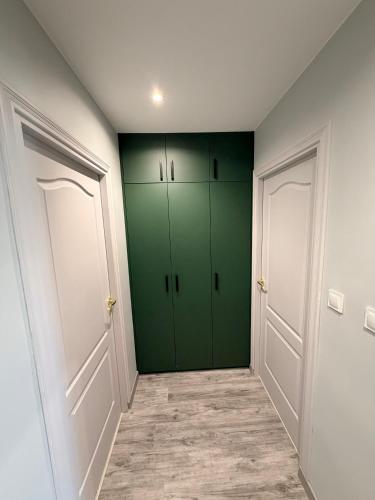 a hallway with green cabinets in a white room at Kwiatowy Zakątek na Zaciszu in Radocza