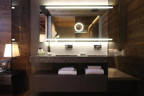 a bathroom with a sink and a mirror and towels at SEVERIN*S – The Alpine Retreat in Lech am Arlberg