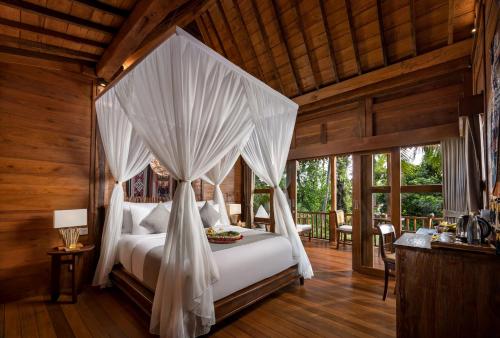 a bedroom with a bed with a canopy at Berlima Boutique Resort in Ubud