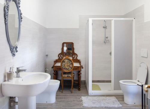a bathroom with a sink and a toilet and a mirror at La Terrazza sul Giardino in Asti