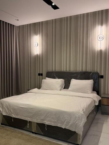 a bedroom with a large bed with white sheets at رُقيّ للشقق الفندقية rogy VIP in Taif