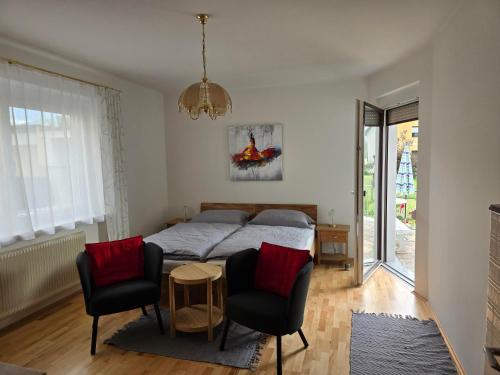 a bedroom with a bed and two chairs and a table at Ferienwohnungen Knaus in Knittelfeld