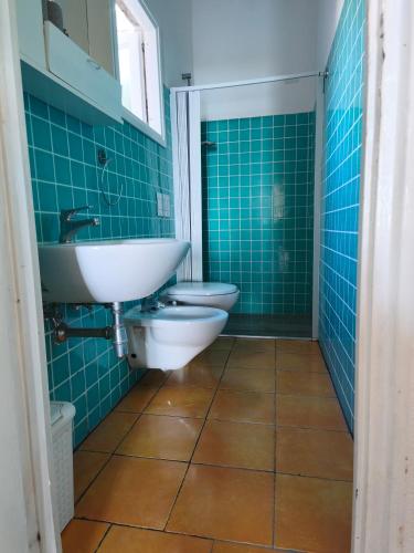 a bathroom with a sink and a toilet and blue tiles at La casita in Capo Vaticano