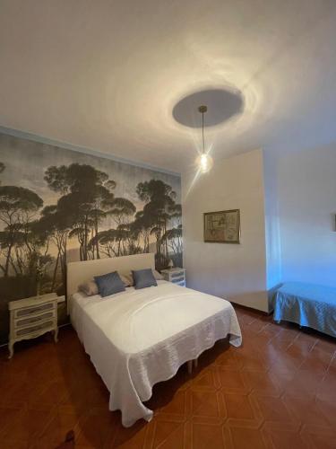 ein Schlafzimmer mit einem weißen Bett und einem Gemälde an der Wand in der Unterkunft Sa Spillunca Experience in Làconi