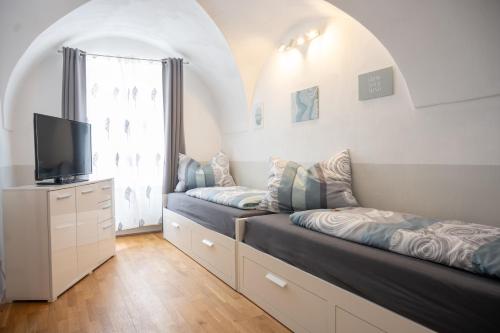 a living room with two beds and a tv at Paky Appartements 00314 in Bruck an der Leitha