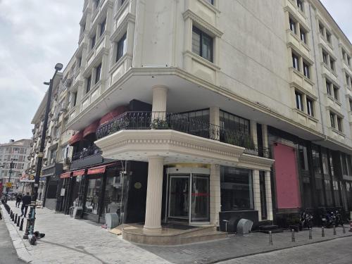 a white building with a balcony on a street at The Parma Hotel Downtown in Istanbul
