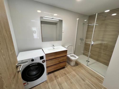 a bathroom with a washing machine and a toilet at Eko apartamentos Astelarra in Muxika