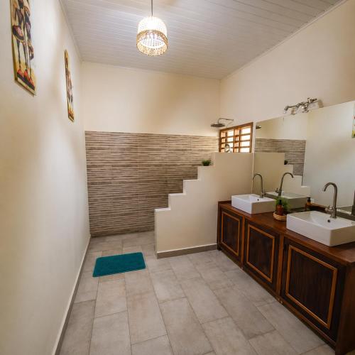 a bathroom with two sinks and a staircase at Le Moya Beach in Nosy Be