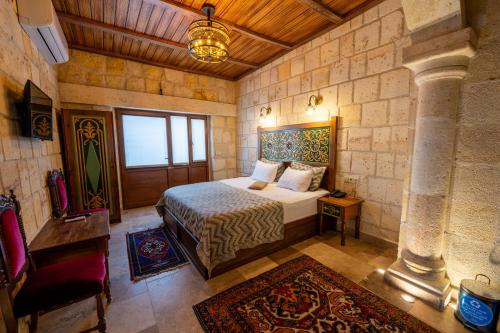 a bedroom with a bed and a chair in a room at Cappadocia Sweet Cave in Nevşehir