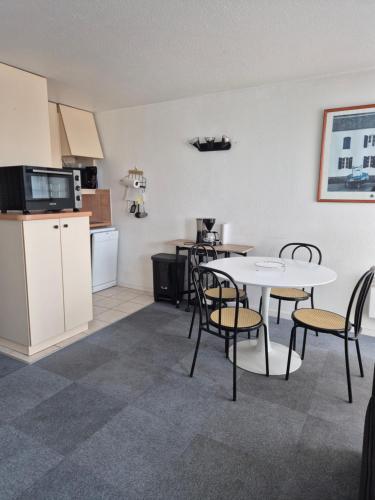 a kitchen and dining room with a table and chairs at Studio avec balcon, 4 personnes in Quiberon