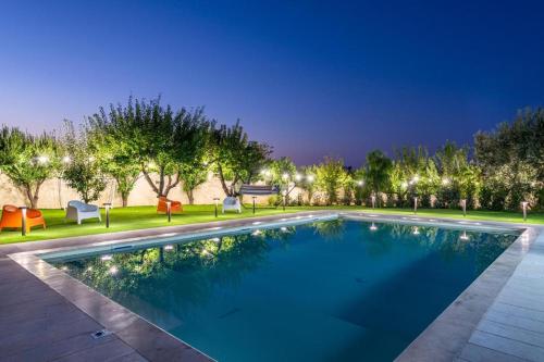 a swimming pool at night with chairs and trees at Blue Coast Luxury Private Villa, Pool, Jacuzzi, Guesthouse in Bisceglie