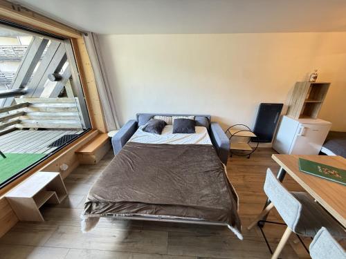 a bedroom with a bed and a large window at Studio Montagne chic centre station in Le Lioran