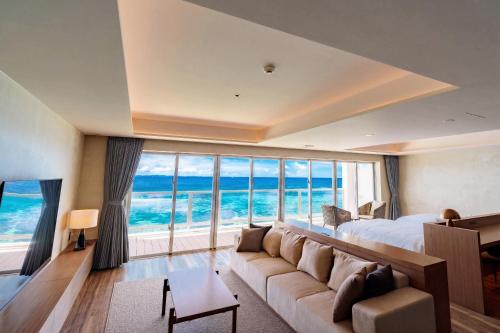 a living room with a couch and a large window at RAV RESORT Okinawa in Yomitan