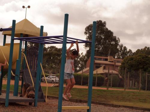 a young girl playing on a playground with a dog at Bundalong Hideaway in Bundalong