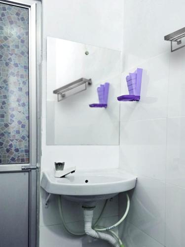 a white bathroom with a sink and a mirror at Jayawikrama Cafe and Guest in Matara