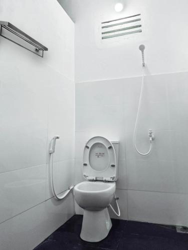 a white bathroom with a toilet with a shower at Jayawikrama Cafe and Guest in Matara