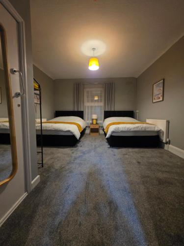 a bedroom with two beds and a lamp in it at Central Guest House in Newport